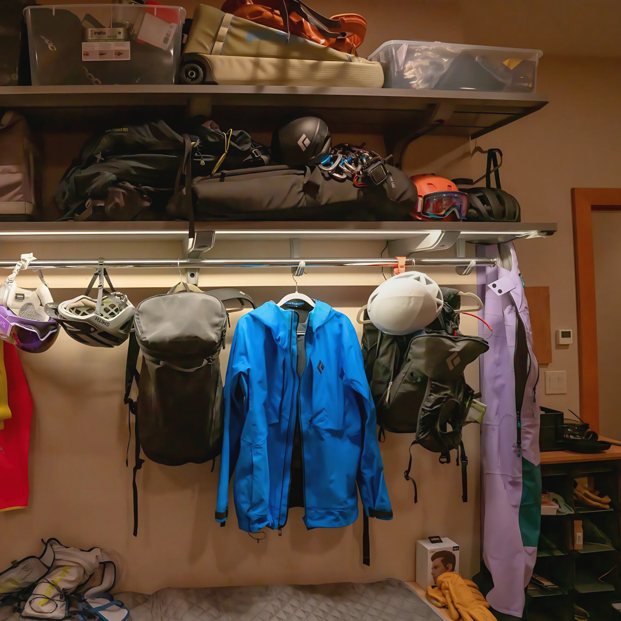 all-groups Shelving unit with various gear including helmets, bags, and jackets in a mudroom