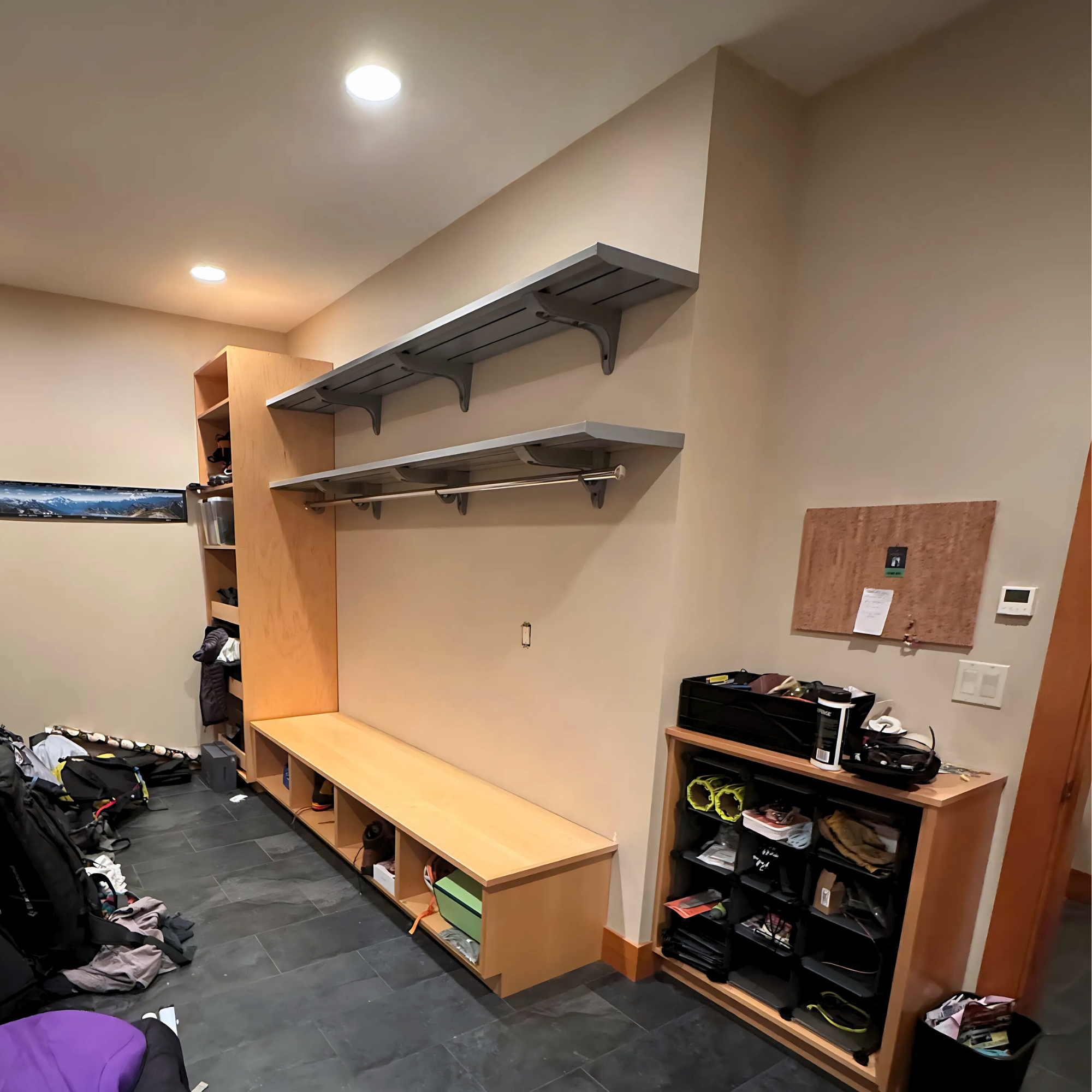 all-groups Storage room with wooden shelves, bench, and various items on a gray floor.