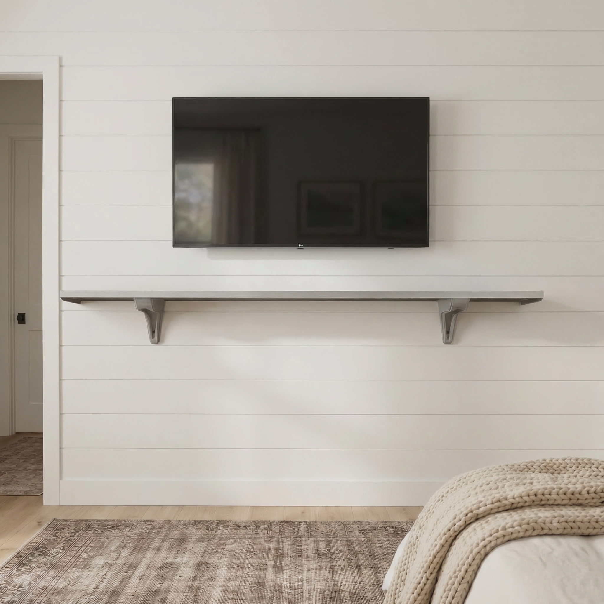 Toden gray modular surface installed as a minimalist floating TV console on a white shiplap wall. The 72-inch gray panel is mounted beneath a wall-mounted television, showcasing the heavy-duty brackets and sleek "no diagonal support" design. This setup demonstrates an industrial-strength media storage solution that doubles as a modern architectural feature in a bedroom or living area.