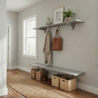 Toden gray modular entryway storage system in a bright, minimalist mudroom. Features a high-mounted gray floating shelf with integrated hooks holding a coat and leather tote bag, paired with a matching lower floating bench for shoe and basket organization. Highlights the "no-diagonal support" bracket design and sleek 72-inch surfaces in a modern residential hallway.