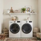Toden white modular shelving system installed as a minimalist laundry room organizer. A single, long-run white floating shelf is mounted above a white front-load washer and dryer, styled with towels, laundry supplies, and a potted plant. The setup highlights the "no-diagonal support" bracket design, creating a sleek and open storage solution for high-traffic utility spaces.