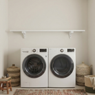 Toden white modular surface installed as a minimalist laundry room organizer above a white front-load washer and dryer. The setup features a single 72-inch white floating shelf supported by industrial-strength brackets, highlighting the sleek "no diagonal support" design. This visual demonstrates a clean, open storage solution that provides heavy-duty capacity in a residential utility space.
